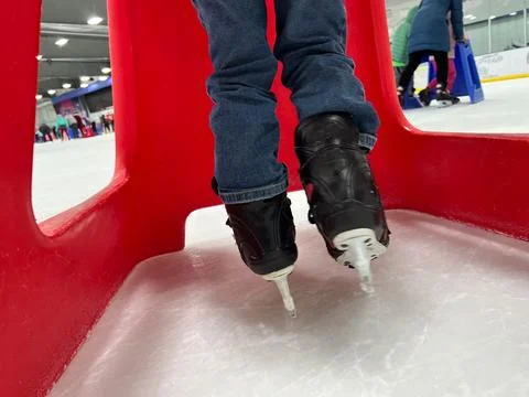 Beginner ice skater using a plastic walker for assistance. Foto stock
