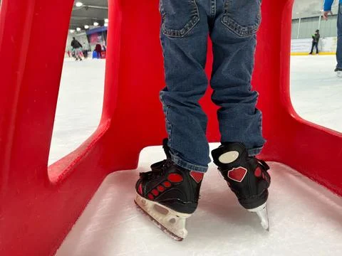 Beginner ice skater using a plastic walker for assistance. Stock Photos