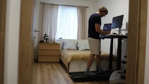 Beginner IT student learns computer skills while walking at his home workstation Stock Footage 347269767