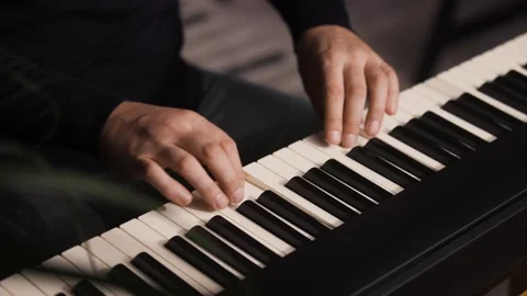 Beginner pianist practicing on a electronic piano keyboard at home Stock Footage 342237456