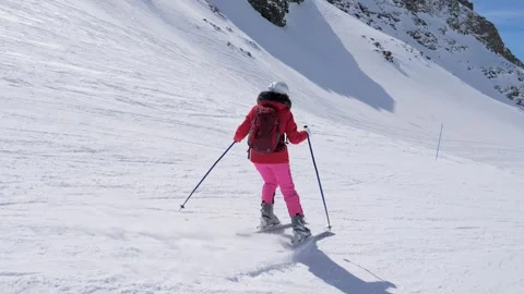 Beginner skier learns how make turns ski on snowy slope in mountains at winter Stock Footage 318655710