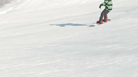 Beginner snowboarder carves down the slope at a ski resort Stock Footage 164043286