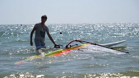 Beginner sport guy try windsurfing water activity on a Black Sea beach Stock Footage 80870723