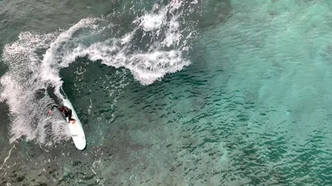 Beginner surfers learning to surf over coral reef shot from drone Video stock 124890448