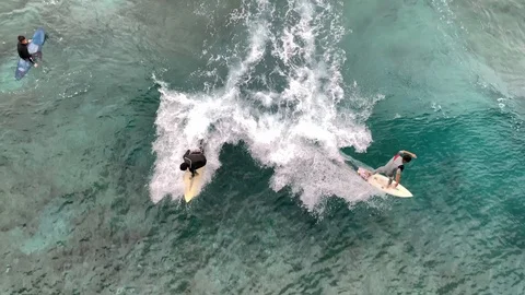 Beginner surfers learning to surf over coral reef shot from drone Stock Footage 124890603