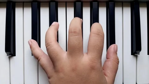 A beginner tries to play black keys on the piano	 Stock Footage 284443827