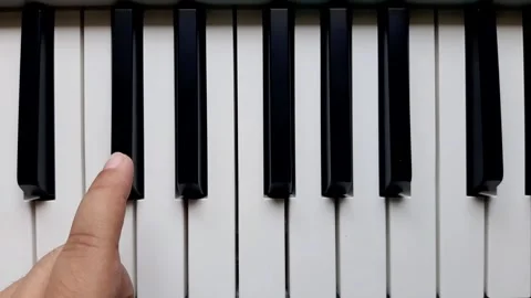 A beginner tries to play black keys on the piano	 Stock Footage 284443912
