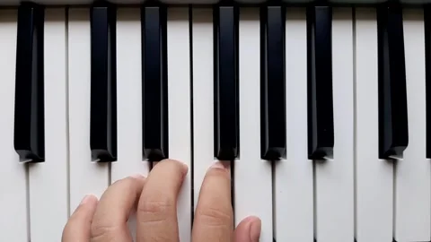 A beginner tries to play left hand on the piano		 Stock Footage 284443882