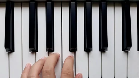 A beginner tries to play left hand on the piano	 Stock Footage 284443926