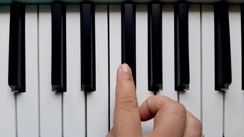 A beginner tries to play the piano	 Stock Footage 284444073