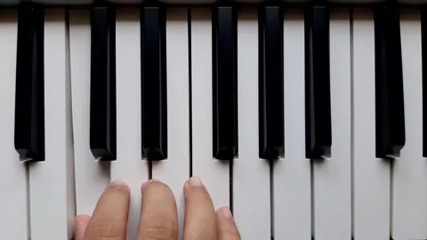 A beginner tries to play the piano	 Stock Footage 284444398