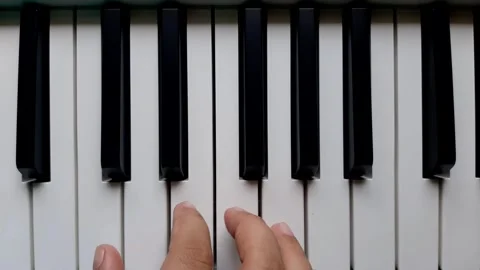 A beginner tries to play piano key Stock Footage 284444225