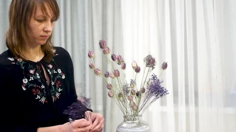 The beginning of the assembly of a composition of dried flowers in a vase cl Stock Footage 241233687