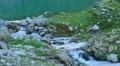 Beginning of clear mountain stream, water flowing between rocks HD Footage