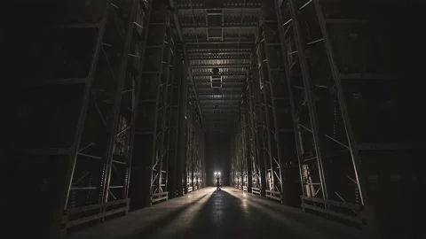 The beginning of the working day at the factory, men walk through the warehouse Видео 133500469