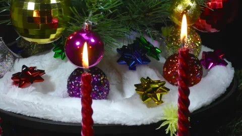 Behind burning candles close-up of a rotating green Christmas tree Stock Footage 166683867