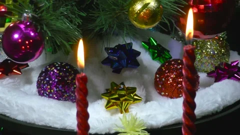 Behind burning candles closeup rotates a decorated Christmas tree Stock Footage 166684169