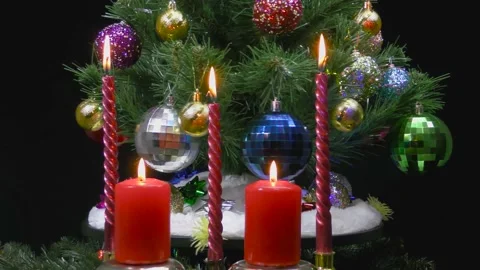 Behind burning candles rotates a large Christmas tree Stock Footage 166683831