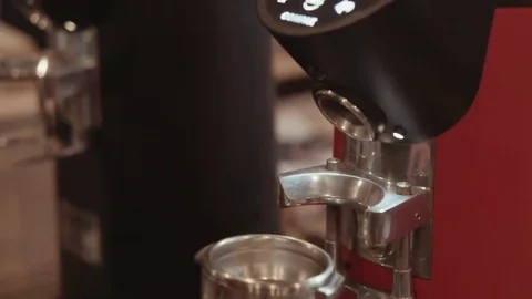 Behind the cafe bar coffee grinder pours ground coffee in holder Stock Footage 69083159