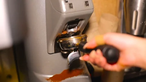 Behind the cafe bar coffee grinder pours ground coffee in holder. HD Stock Footage 81488374