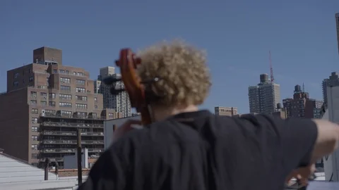 Behind cellist playing on Brooklyn rooftop Stock Footage 111043955