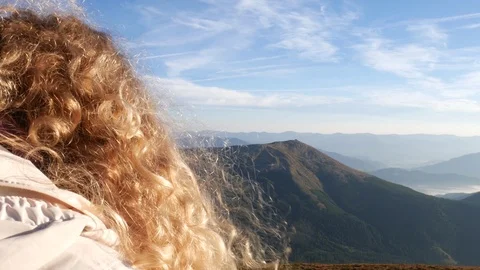 From behind close up: Blonde curly haired girl in mountains Stock Footage 95090159