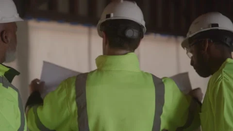 Behind Construction Workers Talking Over Blueprints On Job Site Stock Footage 270389258