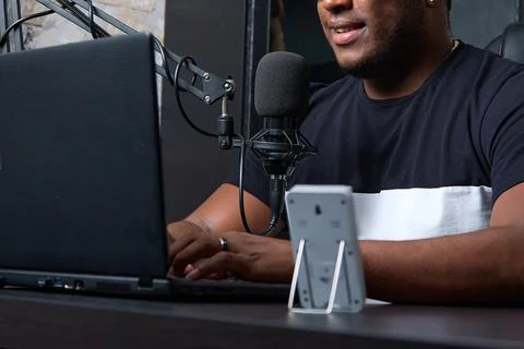 Behind microphone, black live host of popular podcast answers questions Stock Photos