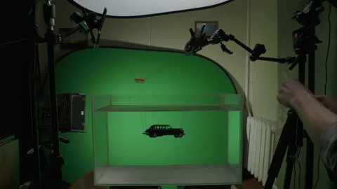 Behind the scene of sinking car in water under sun rays in studio on green Stock Footage 136096936