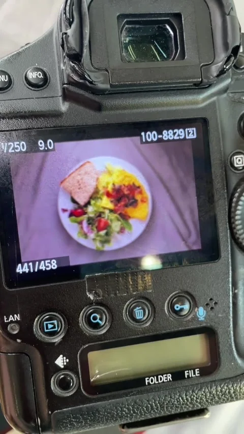 Behind--scenes camera back showing photographer adjusting rear dial while lcd Stock Footage 341626237
