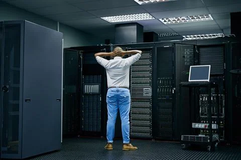 Behind the scenes of an error message. Rearview shot of an IT technician having Stock Photos