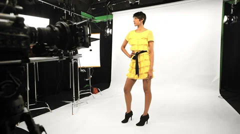 Behind the scenes of a female model being filmed by a male using a Red camera. Stock Footage 33839806