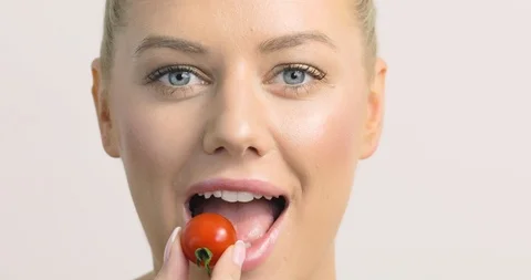 Behind the scenes female model makes a mess eating a cherry tomato. Stock Footage 117343099