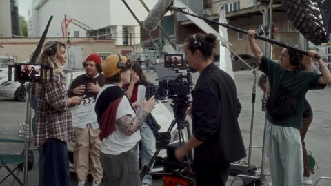 Behind the Scenes of Film Crew Collaborating during Video Production Shoot Stock Footage 336699497