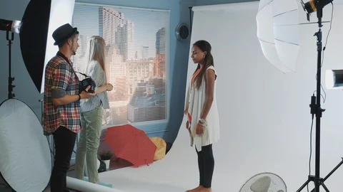 Behind the scenes on photo session: assistant giving model a bar high chair Видео 122575727