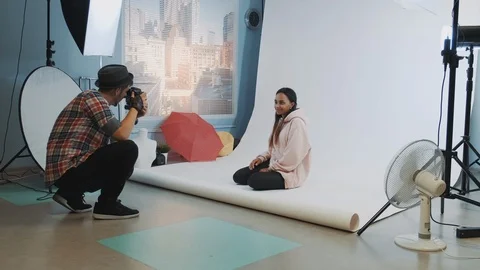 Behind the scenes on photo session: black model posing on the floor for fashion Stock Footage 122580883