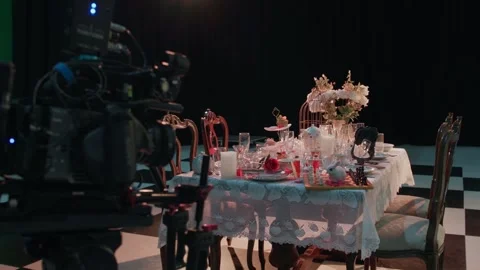 Behind-the-scenes shot of a stylized tea party table set on a film studio 스톡 동영상 333615250