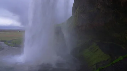 Behind Seljalandsfoss and its Powerful Waterfall Mist in Iceland Stock Footage 325689347