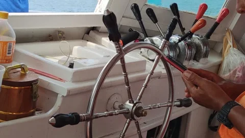 Behind ship wheel Capitan of the stands at the helm and scrolling the phone Stock Footage 246798298