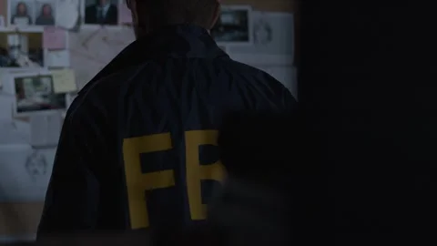 Behind shot of FBI agent looking at Evidence Board Stock Footage 312455393