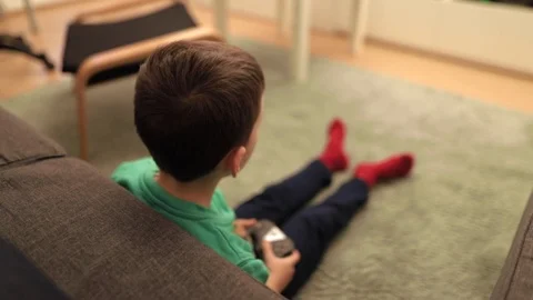 Behind the shoulder shot of a boy gaming at home Stock Footage 102416115