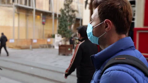 Behind the shoulder view of a tourist with a backpack wearing protective mask Stock Footage 143974517