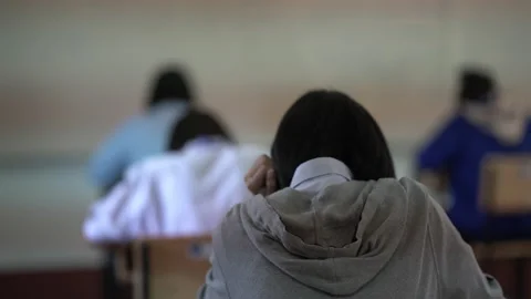 Behind student sitting in classroom for education test Video stock 163080528