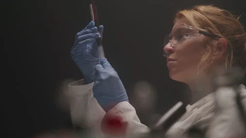 From Behind Test Tubes  Research Scientist Measures Out Blood Sample in the Lab Stock Footage 208798010