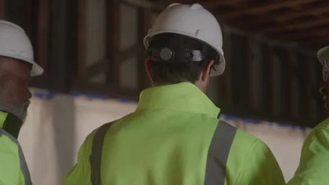 Behind View Of Construction Workers Discussing Plans Stock Footage 270389326
