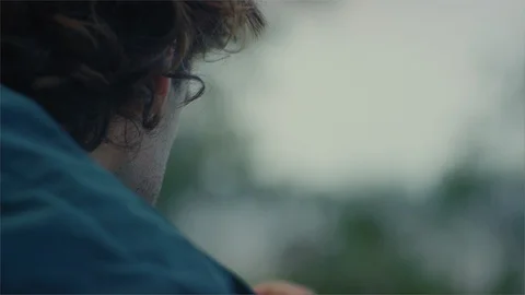 Behind a young man with a photo camera talking a photograph in the forest Video stock 107247477