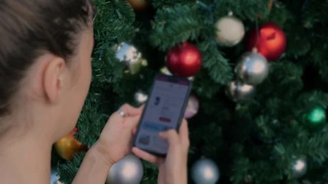Behind‑the‑shoulder view of young woman using smartphone in front... Stock Footage 323733120