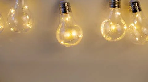 Beige background of bright light bulbs Stock Photos