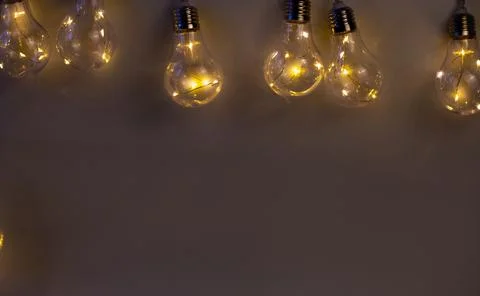 Beige background of bright light bulbs Stock Photos