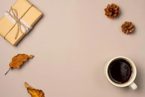 Beige background with gift box and cup of coffee. Autumn composition. Top v.. Stock Photos